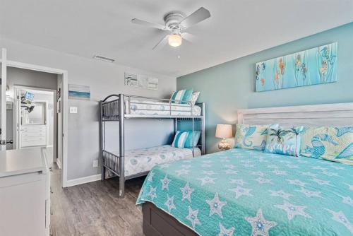 ein Schlafzimmer mit einem Bett und einem Etagenbett in der Unterkunft South Winds unit 2-Gorgeous Newly Updated Condo in the Heart of Gulf Shores!! in Gulf Shores