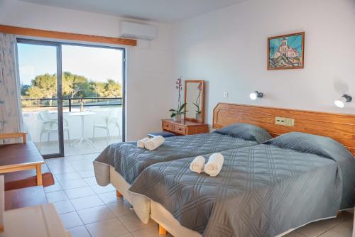 a bedroom with a bed with two towels on it at Konnos Bay Gardens in Protaras