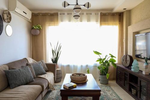 a living room with a couch and a tv at Rotem Home in Haifa
