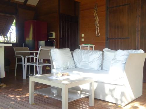 a living room with a white couch and a table at Le matelot de la baie in Deshaies