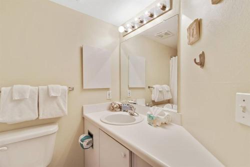 une salle de bain blanche avec un lavabo et un miroir dans l'établissement Summer Breeze #25 - Modest Beachfront with views of the Pass! Great Location!, à Orange Beach