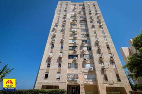 a tall building with windows and balconies on it at Rotem Home in Haifa