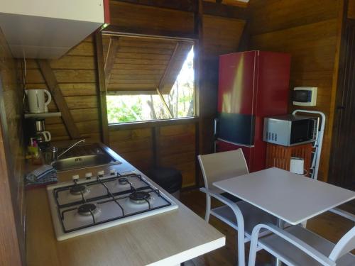 a kitchen with a stove and a sink in a room at Le matelot de la baie in Deshaies