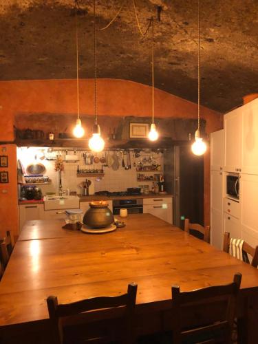 una gran mesa de madera en una cocina con luces en L'antico Molino, en Lubriano