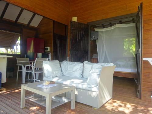 a living room with a white couch and a table at Le matelot de la baie in Deshaies