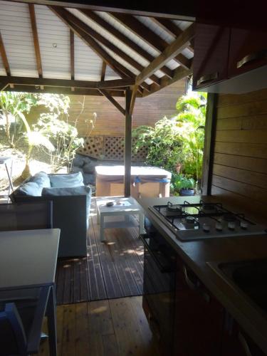 a kitchen with a stove and a patio at Le matelot de la baie in Deshaies