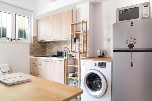 una cocina con lavadora y secadora. en Boho Blu by A&D Properties, en Porto Rafti