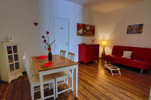 - un salon avec une table et un canapé rouge dans l'établissement Anamonì Bed and Relax, à Bénévent