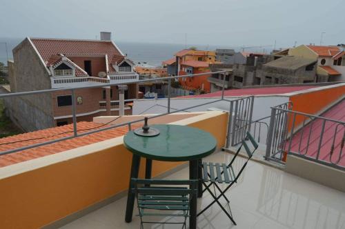 une table et des chaises sur le balcon d'un bâtiment dans l'établissement Apartamento T1 Mobilado com Wi-Fi, à Praia