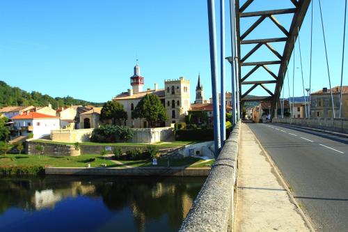 a bridge over a river next to a city at le mas des cerisiers le temple sur lot in Le Temple-sur-Lot