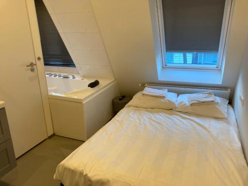 um pequeno quarto com uma cama e uma banheira em Wellness Suite Utrecht em Utrecht