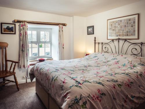 a bedroom with a bed with a floral bedspread at Bastle House in Haltwhistle