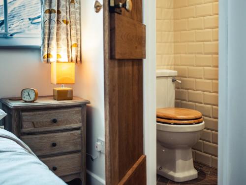 a bathroom with a toilet and a wooden door at Bastle House in Haltwhistle