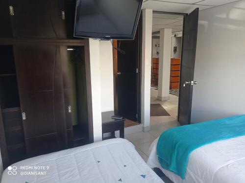 a bedroom with a bed and a flat screen tv at Refugio Turistico & Restaurante Dylam in Aquitania