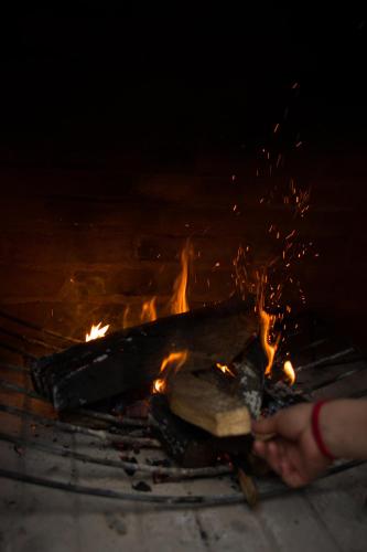 a person holding a piece of wood over a fire at Taller de Juan - Casa Hotel in San Cristóbal de Las Casas