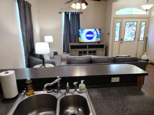 a kitchen with a sink and a living room at Villa 5 in Hammond