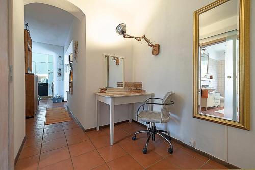 a room with a desk and a mirror and a chair at La Maison de Coco in Muzzano