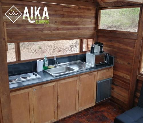 a kitchen with a sink and a microwave at AIKA Reserva Glamping Tabio in Tabio
