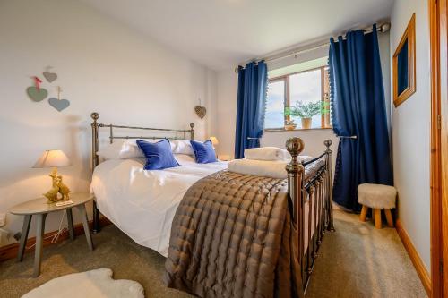 アンブルサイドにあるShepherd's Cottageのベッドルーム1室(青いカーテン付きのベッド1台付)