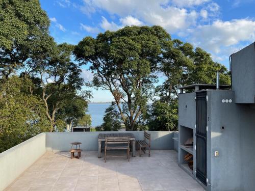 une terrasse avec une table et des chaises et l'océan dans l'établissement Espectacular departamento sobre la laguna para parejas, à Chascomús
