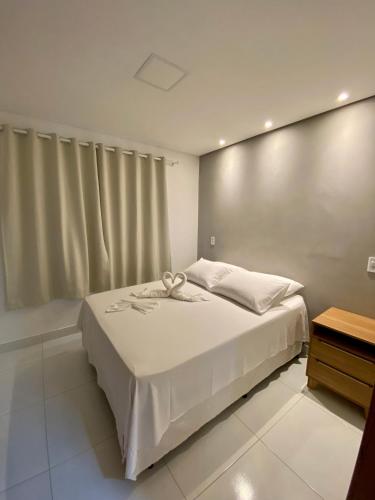 a bedroom with a large bed with white sheets at Acoara PRAIA in Jericoacoara