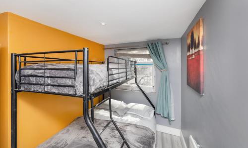 a bunk bed in a room with a yellow wall at Stockton town centre studio apartments free parking and Wi-Fi in Stockton-on-Tees