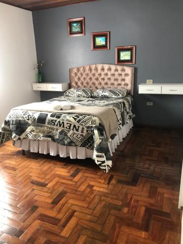 a bedroom with a bed and a wooden floor at Casarão Villa maggi in Canela