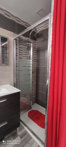bagno con doccia con tenda rossa di MGT - Appartamento sulla Spiaggia con terrazza romantica a Puerto Rico de Gran Canaria