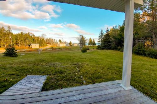 a view of a yard from the porch of a house at Glenghorm Beach Resort in Ingonish