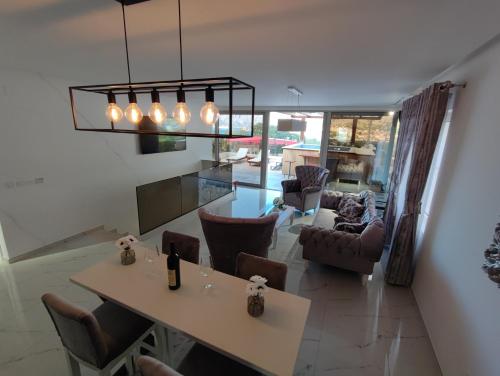 a dining room and living room with a table and chairs at Villa Vista Real in Kotor