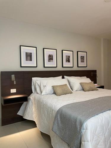 a bedroom with a large bed with three pictures on the wall at HIDALGO 119 - TERRAZA Y SUITES in Zacatecas