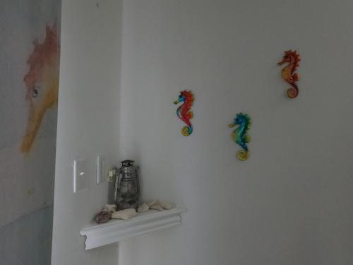 a white wall with four seahorses on it at Breathtaking View - Playa Lagun - Curacao in Lagun