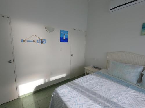 a bedroom with a bed and a white wall at Breathtaking View - Playa Lagun - Curacao in Lagun