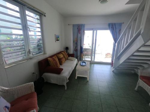 a living room with a couch and a staircase at Breathtaking View - Playa Lagun - Curacao in Lagun