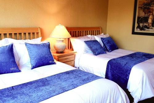 two beds in a room with blue and white at Glenghorm Beach Resort in Ingonish
