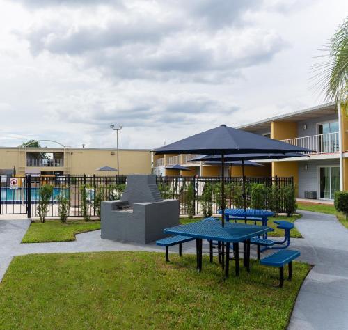 two picnic tables and an umbrella in a courtyard at Celebration Suites in Orlando