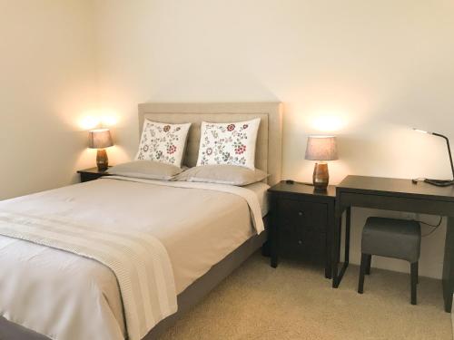 a bedroom with a bed and a desk with two lamps at Perfect Apt near UCLA w Parking Gym Pool WIFI in Westwood B3 in Los Angeles
