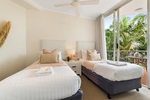two beds in a bedroom with a balcony at Penthouse with Private Roof top terrace- NOOSA in Noosa Heads