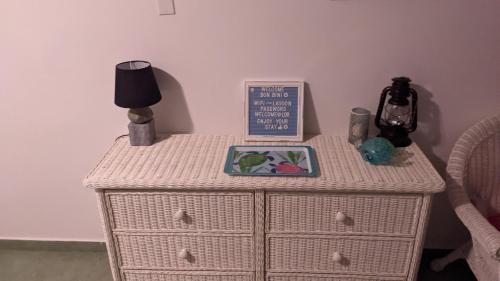 a table with a nightstand with a clock and a lamp at Breathtaking View - Playa Lagun - Curacao in Lagun