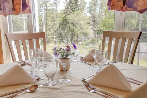 a table with glasses and utensils on a white table cloth at Glenghorm Beach Resort in Ingonish