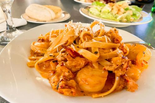 a plate of food with pasta on a table at Glenghorm Beach Resort in Ingonish