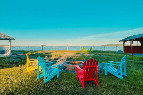a group of chairs sitting around a fire pit at Glenghorm Beach Resort in Ingonish