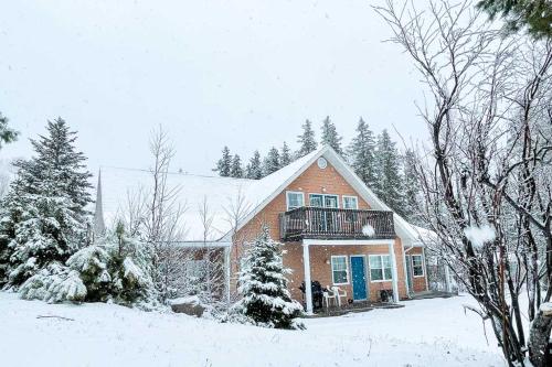 a large house with a balcony in the snow at Glenghorm Beach Resort in Ingonish
