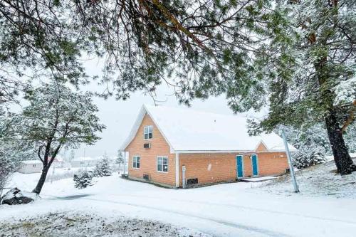 a house is covered in snow in a yard at Glenghorm Beach Resort in Ingonish