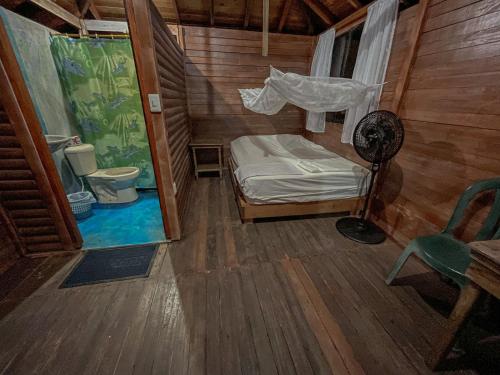 una pequeña habitación con una cama y una silla en Posada Don Aí, en El Valle