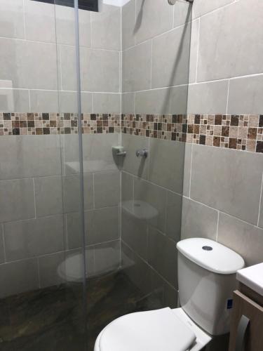 ein Bad mit einem WC und einer Glasdusche in der Unterkunft Villa privada en condominio San Simon in Carmen de Apicalá