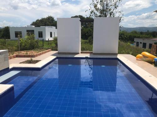 a swimming pool with blue tiles in a backyard at Villa con piscina privada y zona bbq en condominio in Carmen de Apicalá