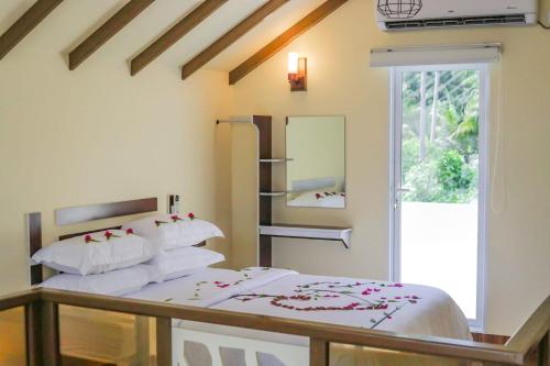 a bedroom with two beds and a window at Relax Villa in Thoddoo