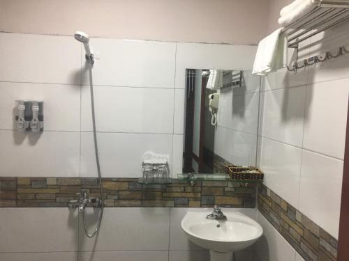 ein Bad mit einem Waschbecken und einem Spiegel in der Unterkunft Mintu Home in Sa Pa