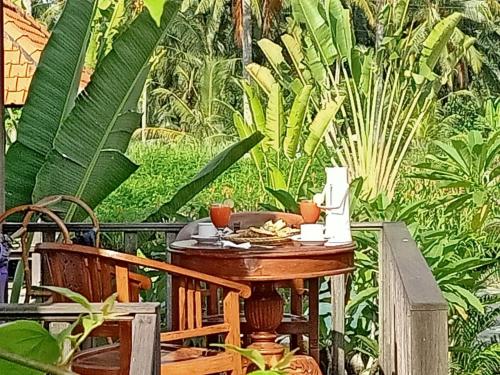 una mesa de madera en un jardín con plantas en Taman Bintang Villa Ubud, en Ubud